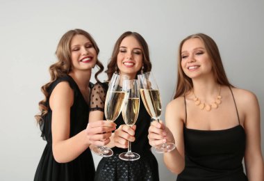 Bardak şampanya ışık arka plan üzerinde olan güzel genç kadın