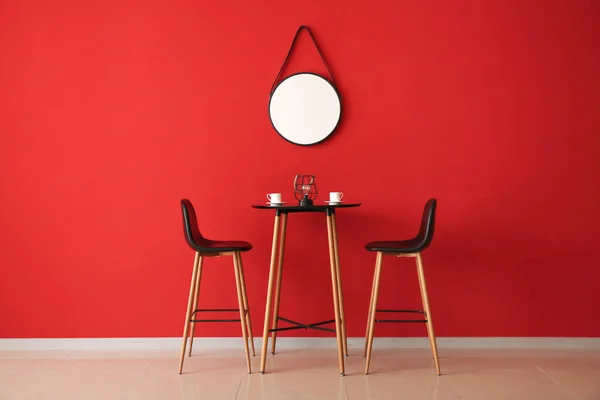 거울과 색상 벽 근처 테이블과 의자 — 스톡 사진