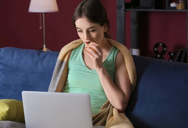 Krásná mladá žena s laptopem konzumní v noci nezdravé jídlo — Stock fotografie