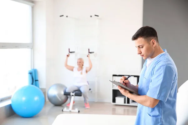 Young male physiotherapist in rehabilitation center — Stock Photo, Image