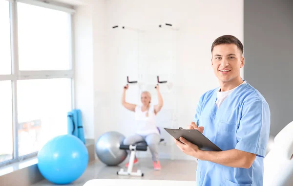 Young male physiotherapist in rehabilitation center — Stock Photo, Image