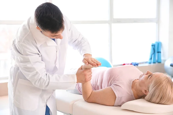 Physiotherapist working with mature patient in rehabilitation center — Stock Photo, Image