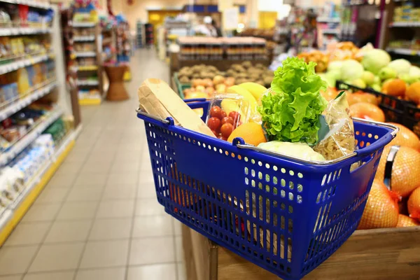 Cesta de la compra con productos frescos en el mercado de comestibles moderno — Foto de Stock