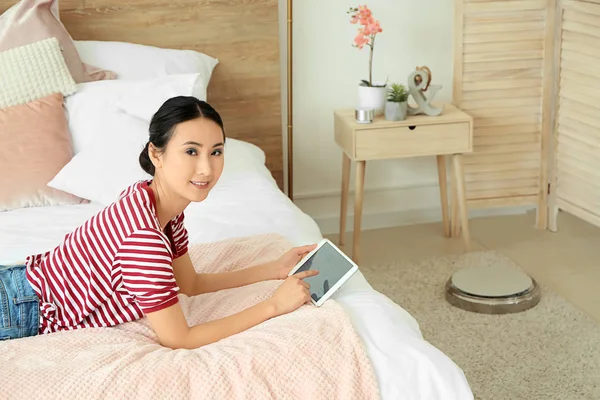 Mladá asijská žena používající aplikaci Smart Home automatizace v ložnici — Stock fotografie