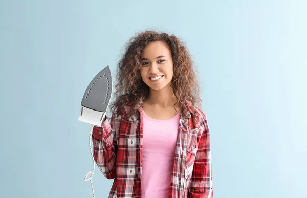 Young woman with iron on grey background — Stock Photo, Image