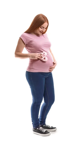 Mulher grávida bonita com botas de bebê no fundo branco — Fotografia de Stock