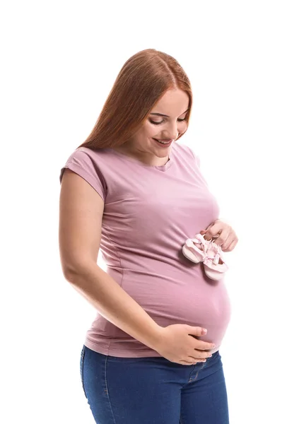 Mulher grávida bonita com botas de bebê no fundo branco — Fotografia de Stock