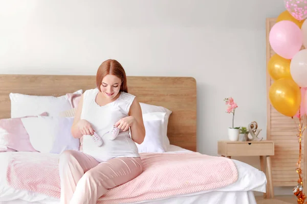Belle femme enceinte assise sur le lit — Photo
