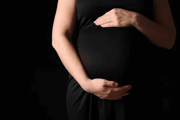 美しい妊婦に暗い背景にクローズ アップ — ストック写真