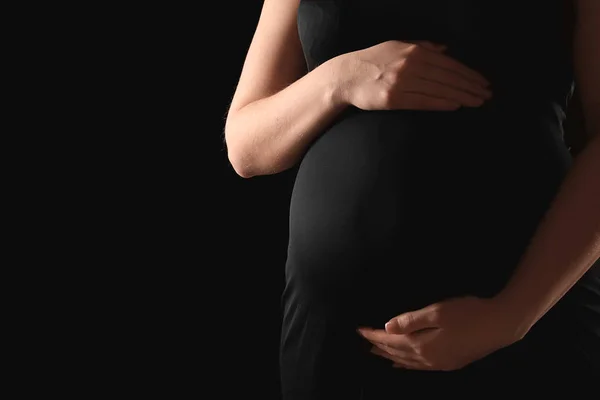 Vakker, gravid kvinne med mørk bakgrunn. – stockfoto