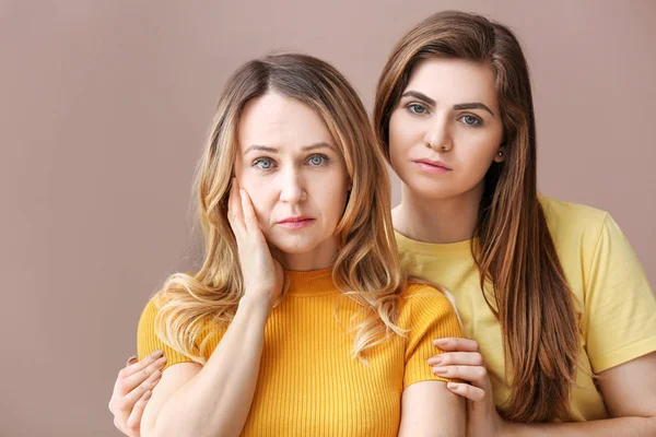 Portrait of mother and daughter on color background — Stock Photo, Image