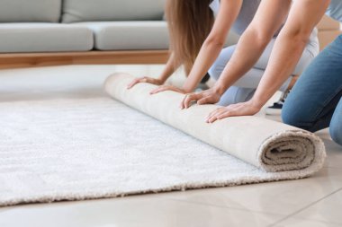 Genç çift yerde halı unrolling