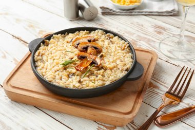 Ahşap masa üzerinde lezzetli risotto ile kızartma tavası