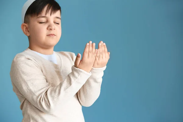 Little Muslim boy praying against color background — Stock Photo, Image