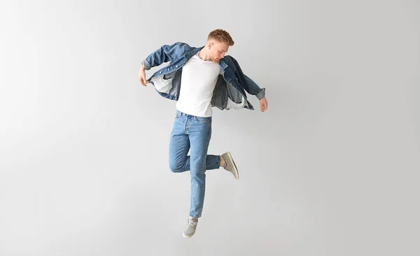 Jumping young man on light background