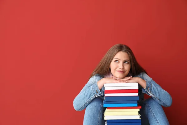 Belle jeune femme avec des livres sur fond de couleur — Photo