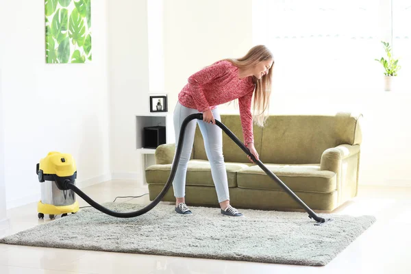 Giovane donna Hoovering tappeto a casa — Foto Stock