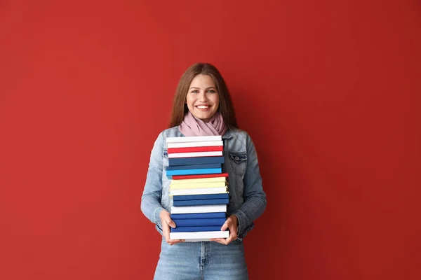 Красивая молодая женщина с книгами на цветном фоне — стоковое фото