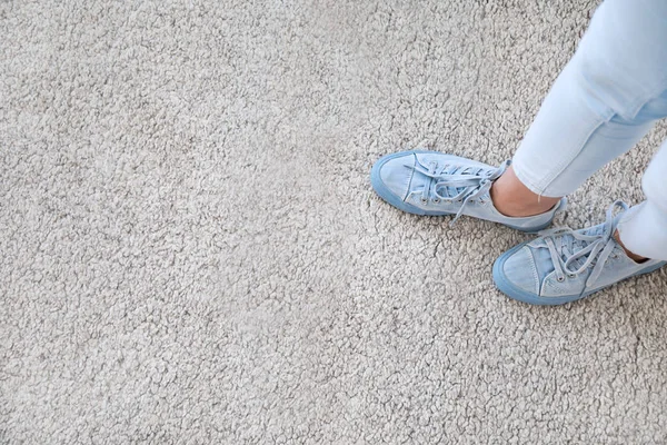 Legs of woman standing on soft carpet, top view — Stock Photo, Image