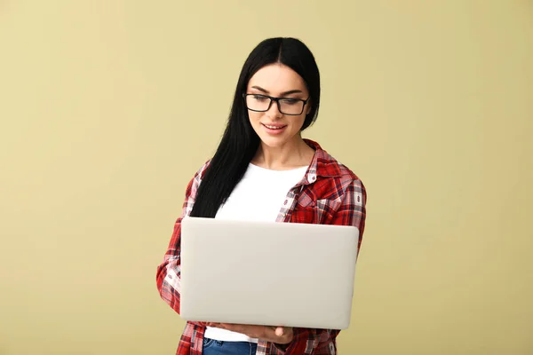 Программист-женщина с ноутбуком на цветном фоне — стоковое фото