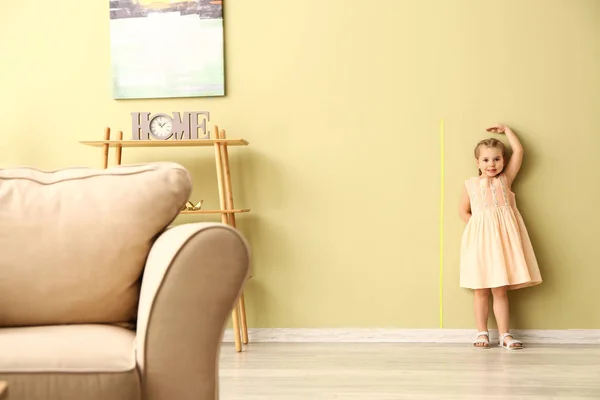 Little girl measuring height near wall — Stock Photo, Image