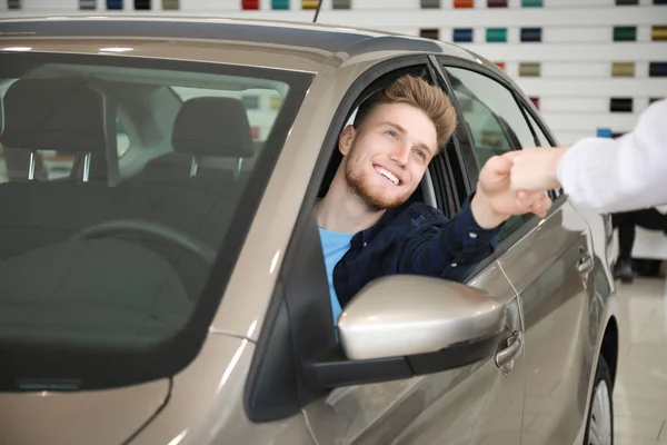 Man buying new car in salon — Stock Photo, Image