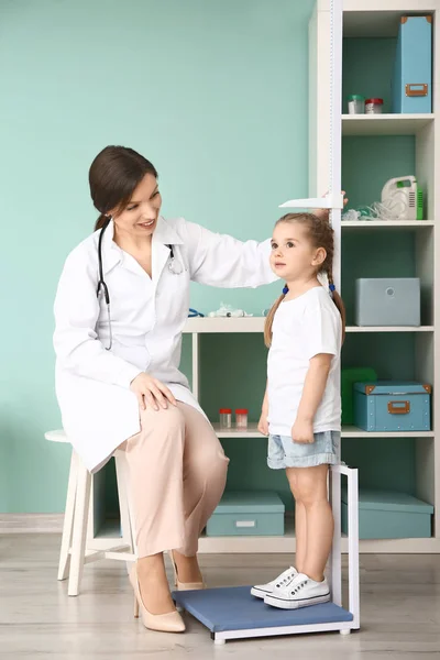 Kobieta lekarz pomiaru wysokości małej dziewczynki w szpitalu — Zdjęcie stockowe