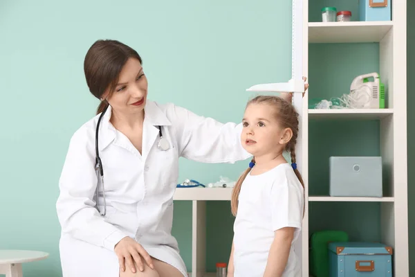 Médico femenino midiendo la altura de una niña en el hospital — Foto de Stock