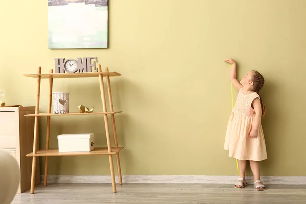 Little girl measuring height near wall — Stock Photo, Image