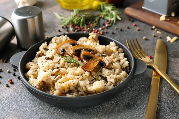 Frying pan with tasty risotto on grey table — Stock Photo, Image