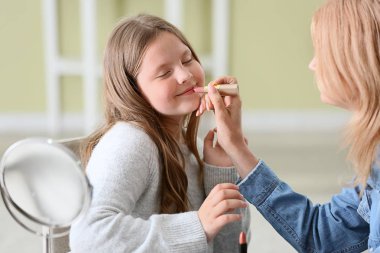 Olgun kadın ve onun sevimli torunu evde makyaj uygulayarak