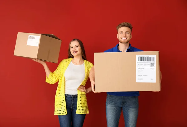 Renkli arka planda karton kutular ile genç çift — Stok fotoğraf