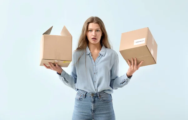 Chockad kvinna med pappkartonger på ljus bakgrund — Stockfoto