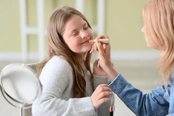 Mujer madura y su linda nieta aplicando maquillaje en casa — Foto de Stock