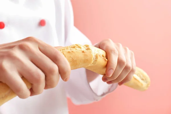 Kobieta piekarz z chlebem na kolorowym tle, zbliżenie — Zdjęcie stockowe