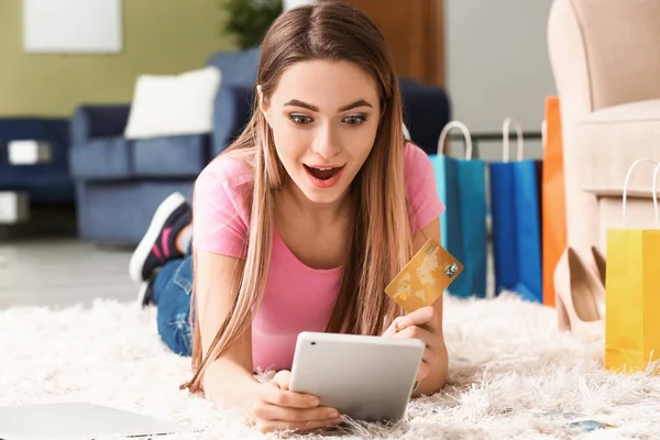 Mulher surpresa com cartão de crédito compras on-line em casa — Fotografia de Stock