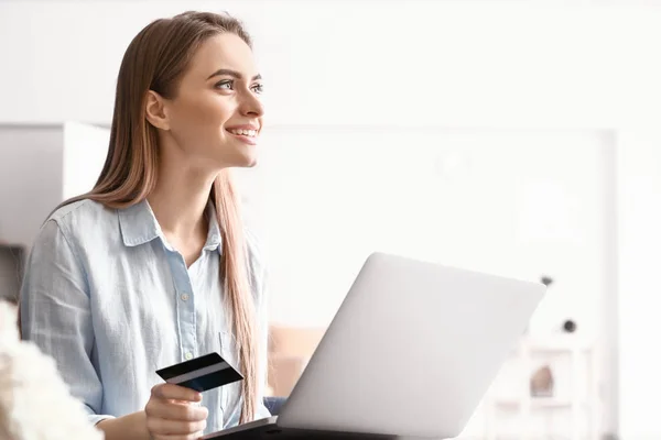 Young woman with credit card shopping online at home — Stock Photo, Image