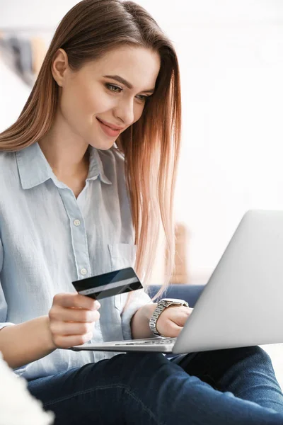 Jonge vrouw met creditcard thuis online winkelen — Stockfoto