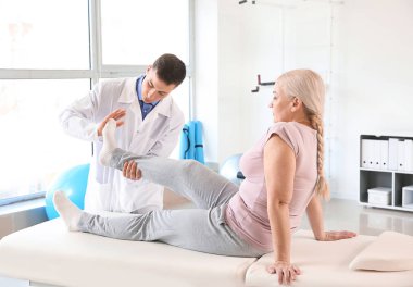 Rehabilitasyon merkezinde olgun hasta ile çalışan fizyoterapist