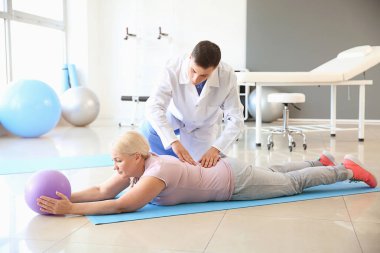 Rehabilitasyon merkezinde olgun hasta ile çalışan fizyoterapist