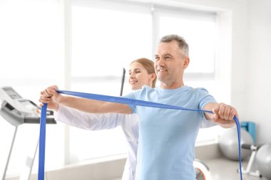 Rehabilitasyon merkezinde olgun hasta ile çalışan fizyoterapist