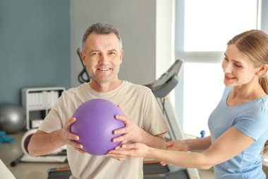 Rehabilitasyon merkezinde olgun hasta ile çalışan fizyoterapist