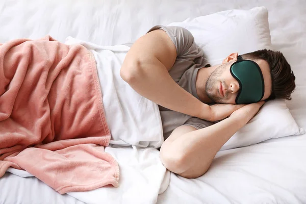 Joven con máscara durmiendo en la cama — Foto de Stock