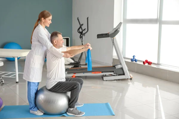 Physiotherapist working with mature patient in rehabilitation center — Stock Photo, Image