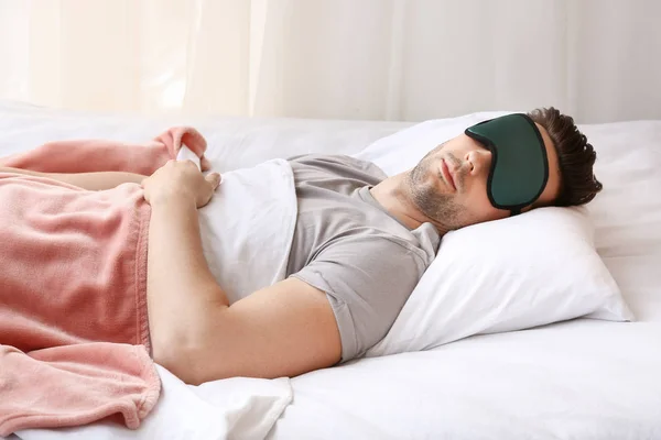 ベッドで眠っているマスクを持つ若い男 — ストック写真