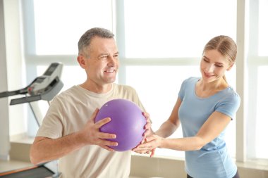 Rehabilitasyon merkezinde olgun hasta ile çalışan fizyoterapist