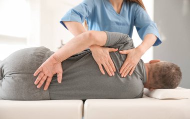 Rehabilitasyon merkezinde olgun hasta ile çalışan fizyoterapist