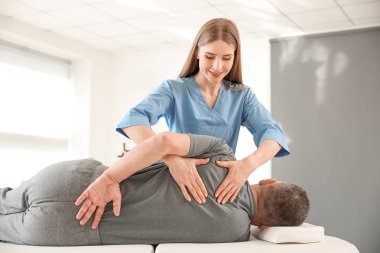 Rehabilitasyon merkezinde olgun hasta ile çalışan fizyoterapist