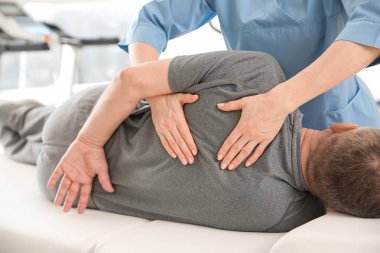 Rehabilitasyon merkezinde olgun hasta ile çalışan fizyoterapist