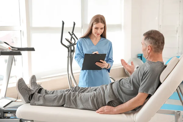 Physiotherapist working with mature patient in rehabilitation center — Stock Photo, Image